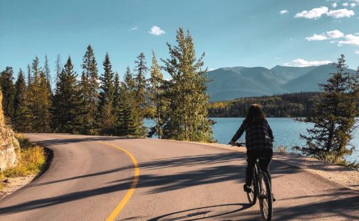 Dívka jede na kole kanadskou přírodou