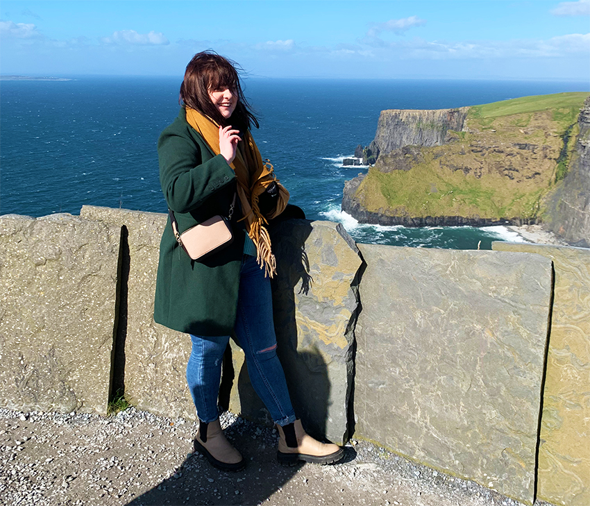 dívka stojí s výhledem na útes v Irsku